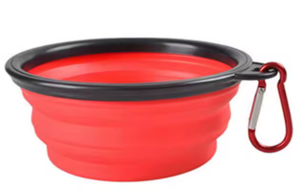 Red silicone travel bowl with black rim and carabiner on a white background