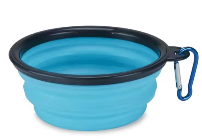 Blue silicone travel bowl with black rim and blue carabiner on a white background