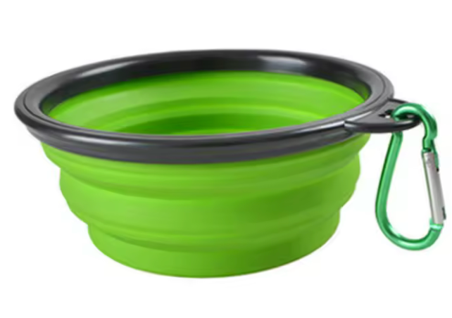 Green collapsible dog bowl with black rim and carabiner on a white background