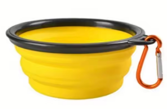 Yellow collapsible dog bowl with black rim and orange carabiner on a white background