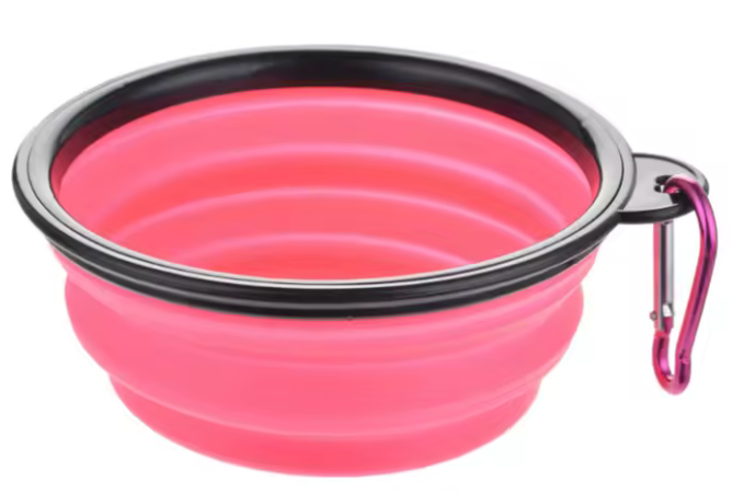 Pink collapsible bowl with black rim and carabiner on a white background